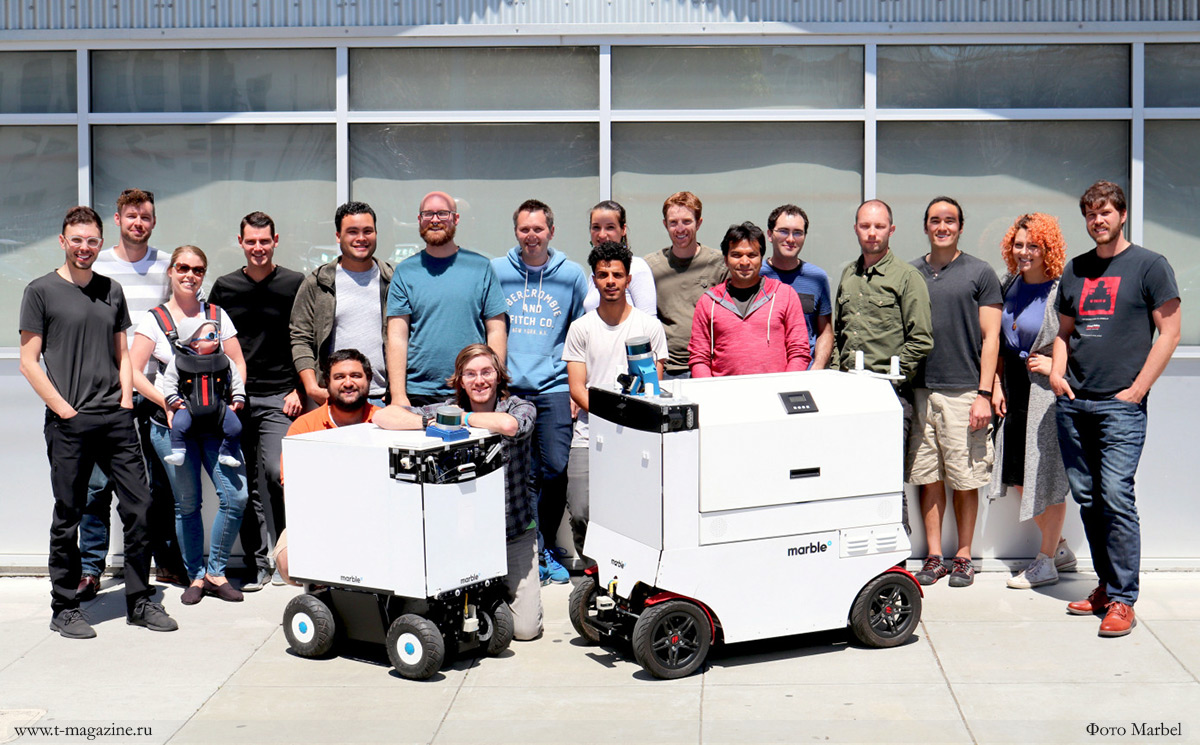 Фото команды Marbel Robot вместе с их продукцией - роботами по доставки продуктов и товаров