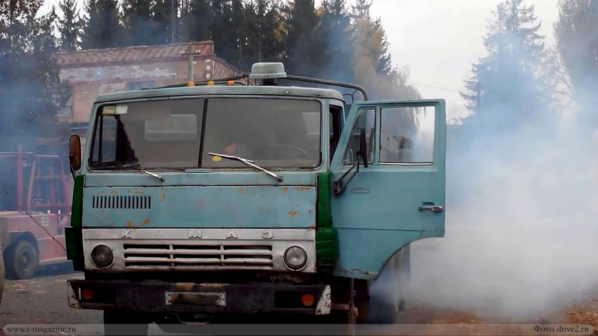 Старый грузовик КамАЗ с дымящим двигателем